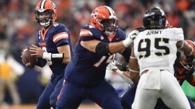 Syracuse quarterback Garrett Shrader, left, looks to pass as offensive lineman Jakob Bradford (74) blocks Army defensive lineman Kyle Lewis (95) during the first half of an NCAA college football game in Syracuse, N.Y., Saturday, Sept. 23, 2023. (AP Photo/Adrian Kraus)