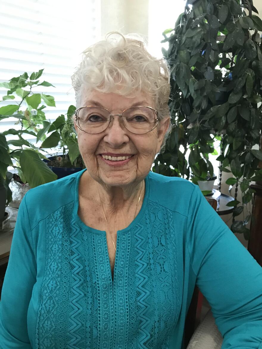 Woman in turquoise poses for photo.