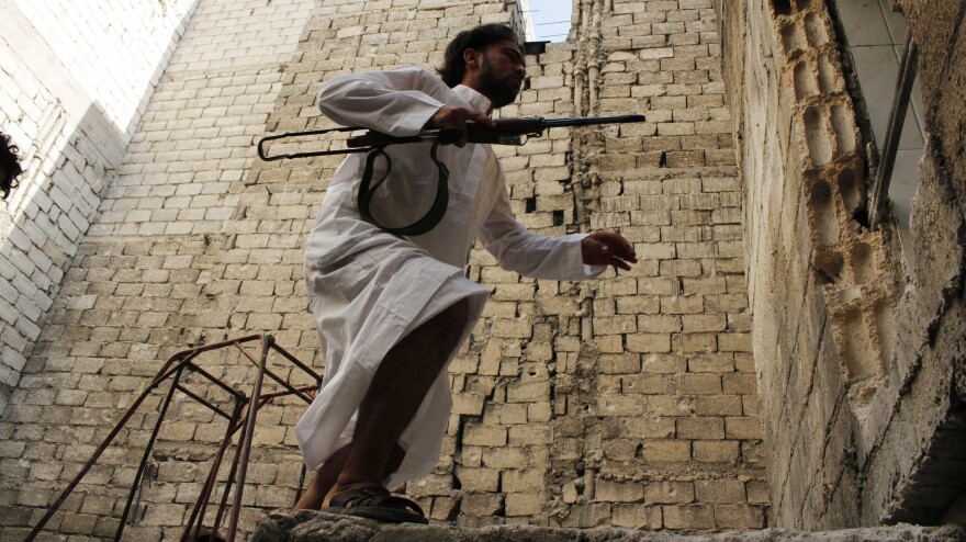 A rebel fighter moves between buildings in the northern Syrian city of Aleppo on Wednesday.