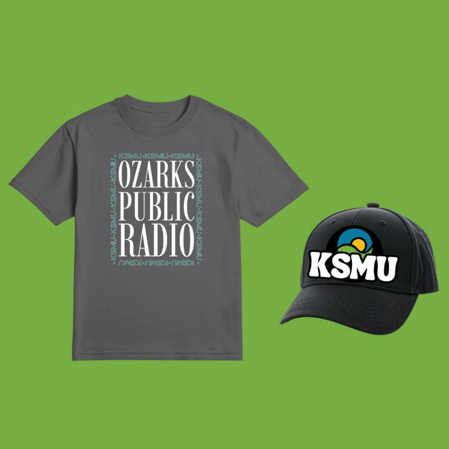 Black KSMU tote bag against green background.
