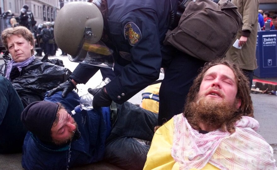 A Seattle police officer uses water to rinse the eyes of protester after making arrest during demonstrations against the World Trade Organization meetings in downtown Seattle on Tuesday, Nov. 30, 1999. 