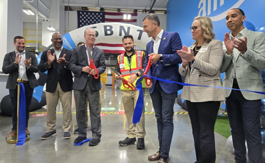 Gov. Mike Braun, Amazon Site Leader Bhautik Motiwala and U.S. Rep. Rudy Yakym help cut the ribbon of Amazon's Elkhart fulfillment center on Oct. 15.