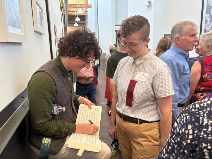 Micah Walter autographs his composition "Revere" for a fellow singer.