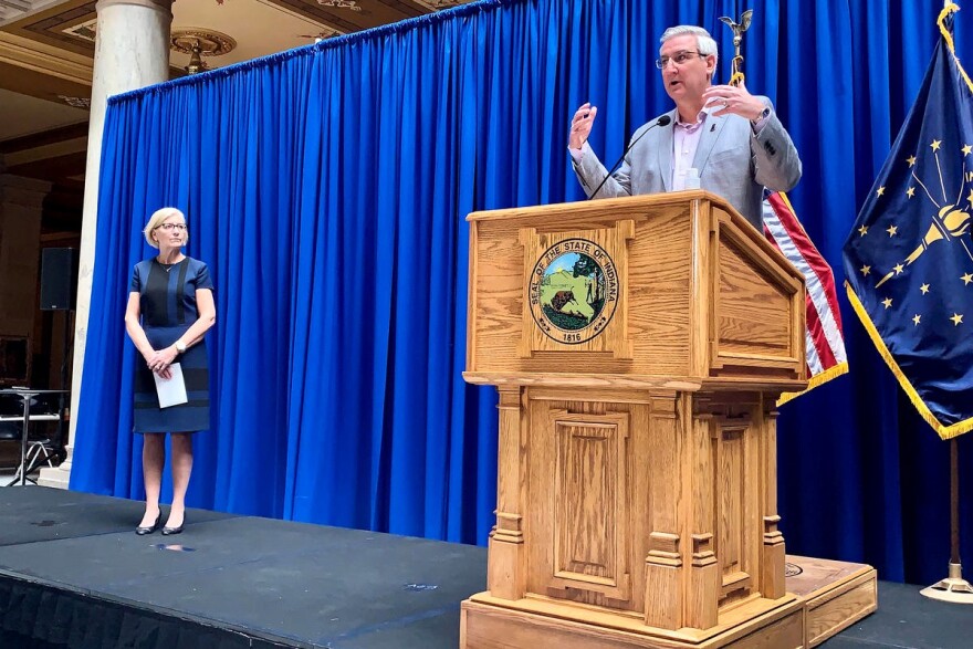 State Health Commissioner Dr. Kris Box, left and Gov. Eric Holcomb practice social distancing during a press conference on COVID-19. (Brandon Smith/IPB News)