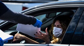 A woman collects unemployment forms at a drive through collection point outside John F. Kennedy Library in Hialeah, Florida, on April 8, 2020. (CHANDAN KHANNA/AFP via Getty Images)