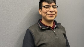 Edgewood ISD Trustee Michael Valdez poses for a portrait in a pullover sweater and a burgundy button up.