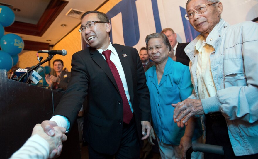 Rhode Island Republican gubernatorial nominee Allan Fung shakes hands with a supporter as his mother, Tan Ping Fung, center, and father, Kwong Wen Fung, right, look on, during a primary election night watch party Tuesday in Warwick.