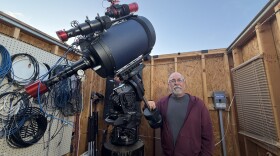 Tom Wildoner stands beside his telescope in his personal observatory.