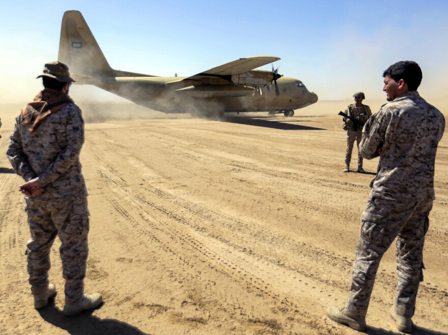 Saudi soldiers stand by as a Saudi Air Force cargo plane carrying humanitarian aid lands at an airfield in Yemen's Marib province on Friday. The Saudi-led coalition, which has led a years-long airstrike campaign supported by the U.S., has also pledged $1.5 billion in new aid.