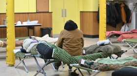 A guest sits on his cot at the Code Blue shelter at The Calvary Bible Church in Wilkes-Barre.