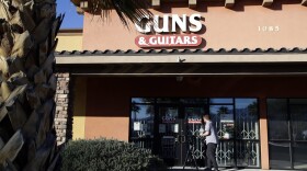 A member of the media takes video footage of the front of the Guns & Guitars store in Mesquite, Nev., Monday, Oct. 2, 2017. The store's general manager Christopher Sullivan said in a statement Monday that Stephen Craig Paddock showed no signs of being unfit to buy guns. (Chris Carlson/AP)