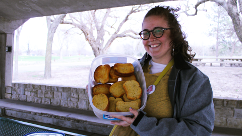 Jenny Pierce, a representative of People's Pride ICT, holds a tray of garlic bread for their event "Gays Eating Garlic Bread in the Park."