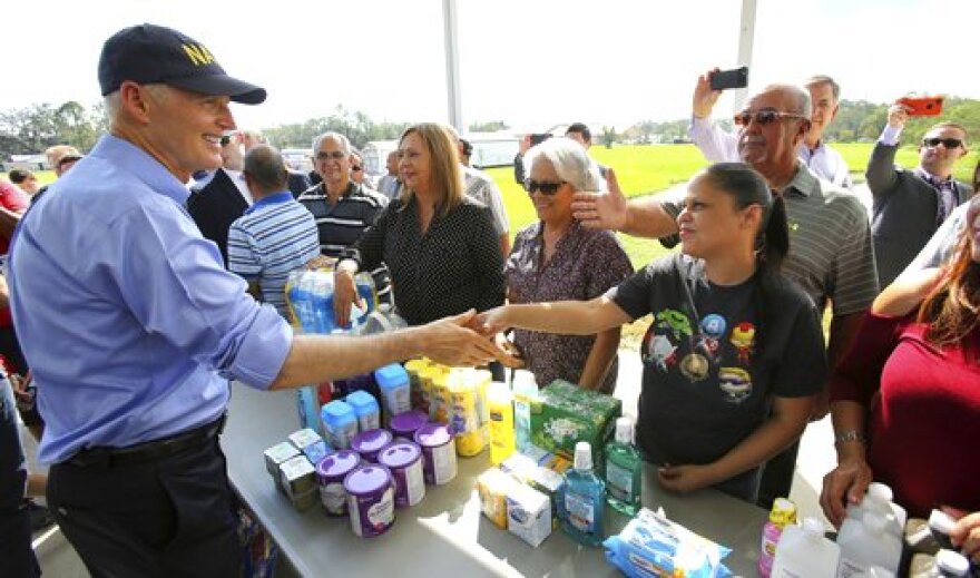 Florida Governor Rick Scott thanks Osceola County volunteers who are assisting with the relief effort for Puerto Rico in the wake of Hurricane Maria, during a visit to the Osceola County Services warehouse, in Kissimmee, Fla., Wednesday, Sept. 27, 2017. (Joe Burbank/Orlando Sentinel via AP)