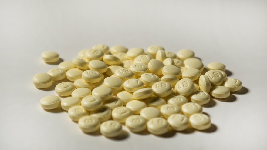 A pile of small round yellow pills with "81" stamped on them.