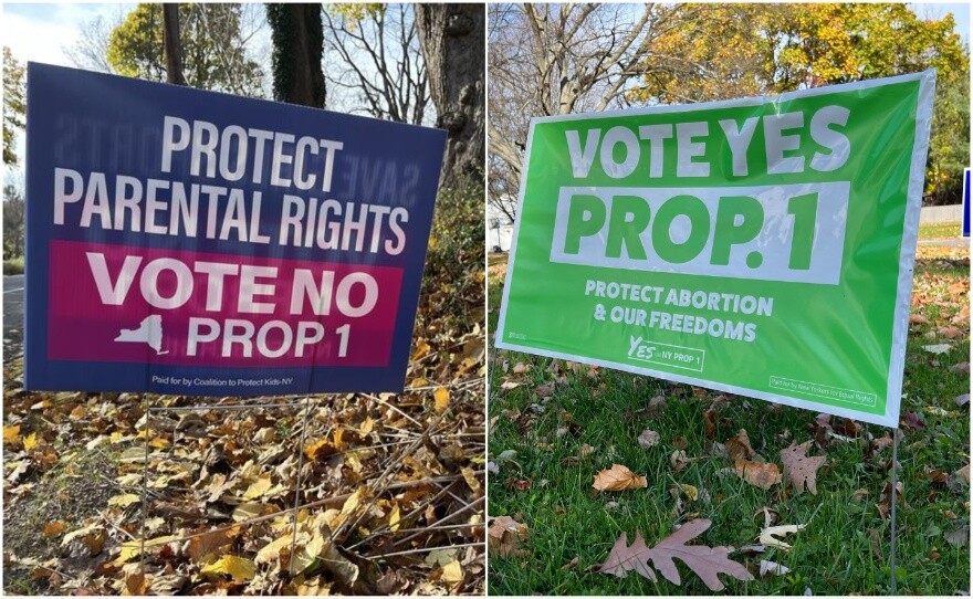 One sign declaring "Protect Parental Rights Vote No Prop 1" and another declaring "Vote Yes Prop 1 Protect Abortion and Our Freedoms"