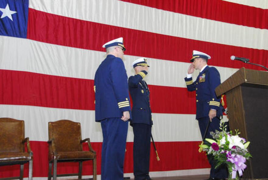 Coast Guard Cmdr. Doug Cameron watches as Cmdr. Edward Sandlin salutes Rear Adm. Thomas Ostebo, commander, 17th Coast Guard District, and assumes command of Air Station Sitka, Wednesday, May 16, 2012. Cameron, the previous Air Station Sitka commander, is transferring to the 5th Coast Guard District where he will serve as the districtâs Chief of Incident Management. U.S. Coast Guard photo by Chief Petty Officer Kip Wadlow.