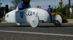 The tween driver steers her soap box racer as it picks up speed heading down the hill from the top of Chevy Commons.