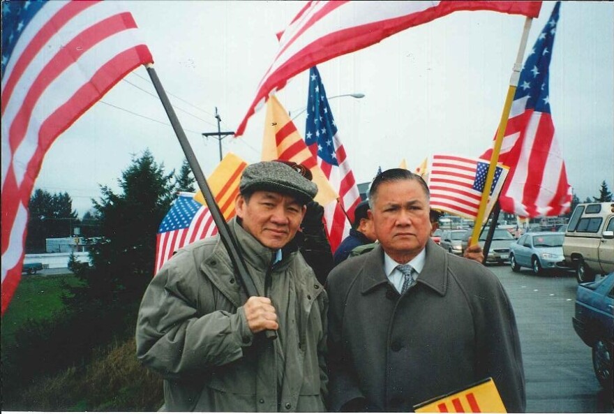 Thanh's father, Duc Tan, holds the American flag and stands next to Dr. Dung Nguyen, president of the Vietnamese Community of Pierce County, at a political rally in this undated photo. Like most other refugees, they still prefer to recognize the flag of t