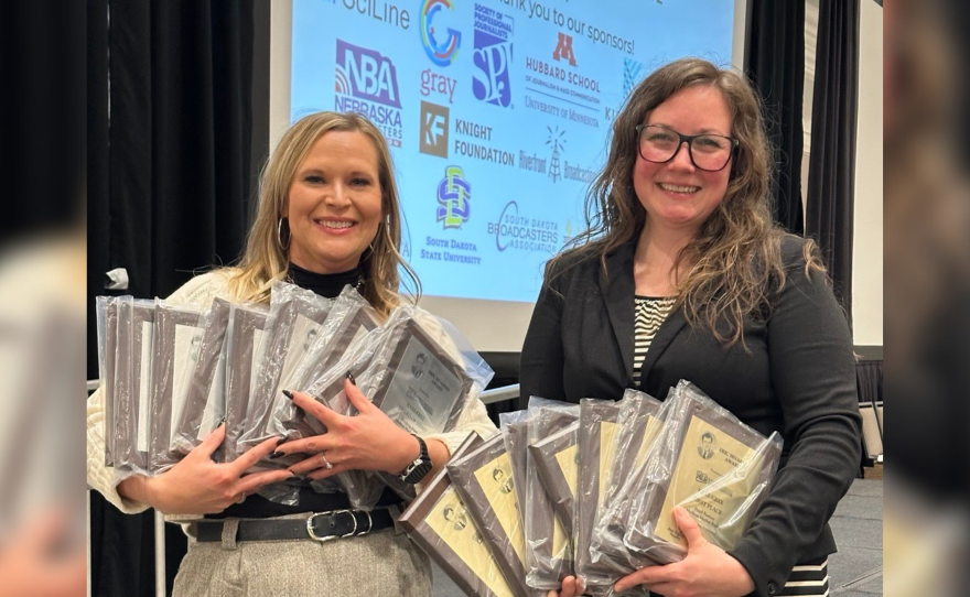 CEO/General Manager Sarah Bignall and News Director Chelsey Perkins hold the 18 Eric Sevareid Awards earned by the KAXE News team at the Midwest Broadcast Journalism Association's 2026 awards banquet April 11, 2026, at the InterContinental St. Paul Riverfront hotel.