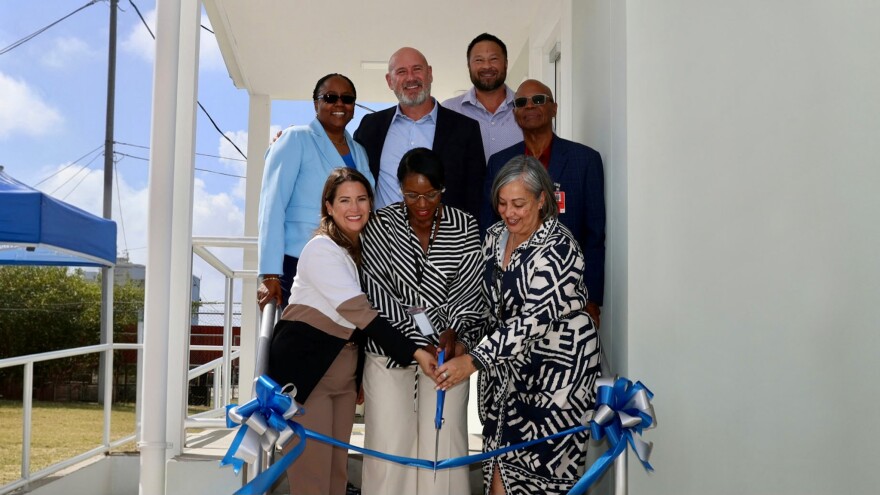 Pictured: Tropical Shipping representatives cut the ribbon to their new administrative and warehouse facility, joined by contractor James Benton, pictured in the back row.