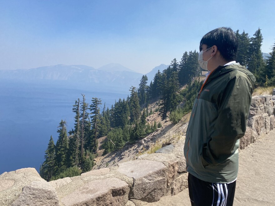 Jia Zhao, a healthcare worker from Portland, looks out at Crater Lake on Wednesday during the 105th anniversary of the park service.