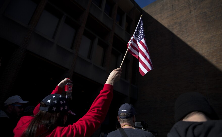 A woman raises an American flag in the air on Saturday, Feb. 10, 2018, at a College Republicans rally at Red Square on the University of Washington campus in Seattle. 