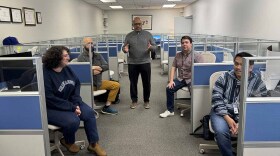 Newly hired Vice President of News Maurice Jones talks with reporters in the WHRO newsroom.
