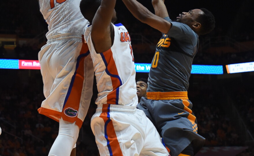 Tennessee's Kevin Punter (0) manages to float a shot over Florida defenders Dorian Finney-Smith (10) and DeVon Walker (1) in the second half. Punter lead Tennessee with 26 points. (Greenberry Taylor/WUFT News)