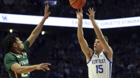 Kentucky's Reed Sheppard (15) shoots while defended by Miami's Nijel Pack, left, during the first half of an NCAA college basketball game in Lexington, Ky., Tuesday, Nov. 28, 2023. (AP Photo/James Crisp)