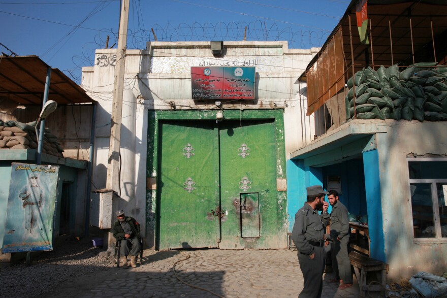 Men guard the gate of a women's prison in Afghanistan.