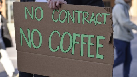 A sign reading "No Contract No Coffee" is held by a Starbucks employee in Columbus.