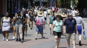 Visitors stroll by shops and restaurants at Disney Springs in Lake Buena Vista in 2016. Despite hurricanes, Zika and the Pulse Nightclub shooting, the state saw a record number of tourists during 2016.(File/AP)