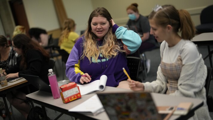 Students Camryn Robinson, left, and Adeline Harrell work together on an in-class project in their "Rhetoric of Walt Disney World" class at New College of Florida, Thursday, March 2, 2023, in Sarasota, Fla. The academic freedom that allows students to design individualized majors is mirrored by a student body that feels free to express itself, say students and faculty, who describe New College as a haven for brainy kids who are high-achieving and intellectually curious. (AP Photo/Rebecca Blackwell)