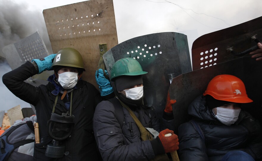 Anti-government demonstrators take cover behind shields as they gather in Kiev's Independence Square. Late last year, President Viktor Yanukovych rejected a trade deal with the European Union in favor of closer ties with Moscow, leading to protests against his government.