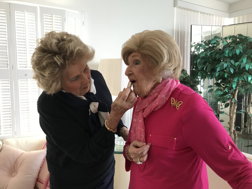 daughter helps mom put on lipstick