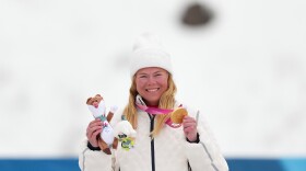 Sydney Peterson, of the United States, poses on the podium after winning the gold medal in the cross country skiing women's 10Km interval start classic standing final at the 2026 Winter Paralympics, in Tesero, Italy, Wednesday, March 11, 2026.