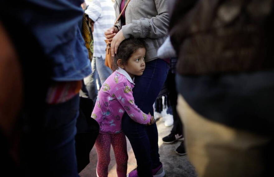 A Central American girl waits with her family at the U.S. border at Tijuana, Mexico, to request asylum.
