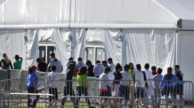 Migrant children line up to enter a tent at the Homestead Temporary Shelter for Unaccompanied Children in Homestead, Fla. in February 2019.