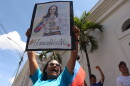 A supporter of opposition leader Maria Corina Machado holds up a poster with her image, during a rally calling for her return to the country and immediately elections in Los Teques, Venezuela, Sunday, Sept. 27, 2026. (AP Photo/Pedro Mattey)