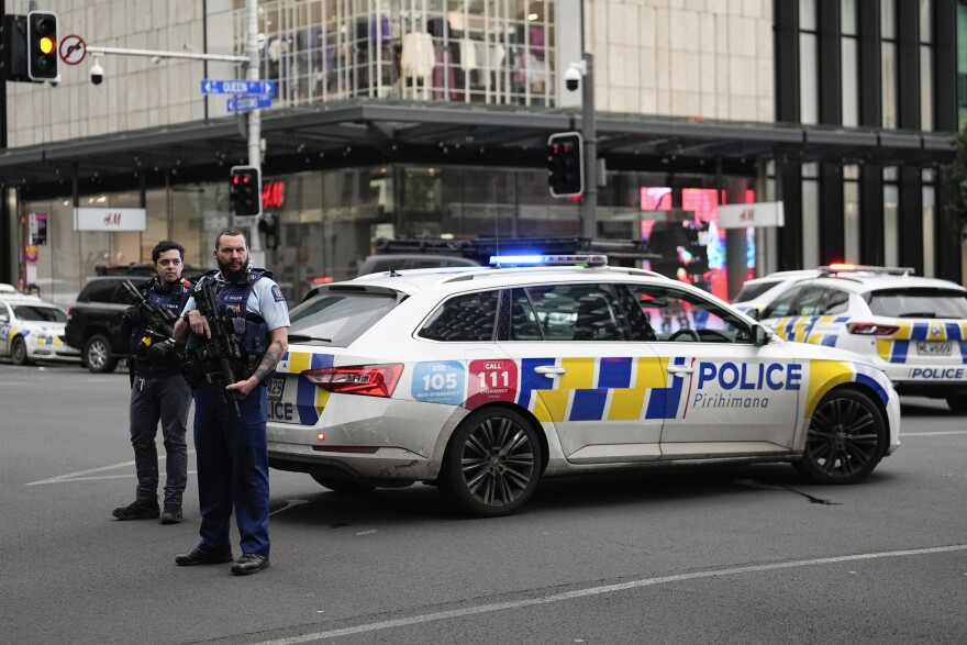 An armed New Zealand police officer stands at a road block in the central business district following a shooting in Auckland, New Zealand, Thursday, July 20, 2023. New Zealand police are responding to reports that a gunman has fired shots in a building in downtown Auckland. (AP Photo/Abbie Parr)