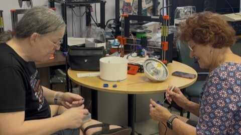 Clare Holman (left) explains to an attendee how to repair her cat’s water fountain.