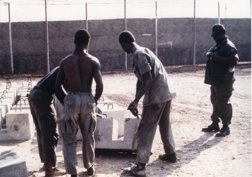 Prisoners on work duty, making aircraft security blocks.