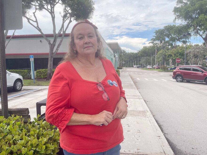 A woman stands on a sidewalk. 