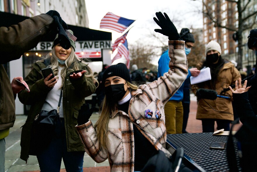 Leslie Lopez, 18, from California, shows off her pins showing President Biden and Vice President Harris outside a restaurant in Washington, D.C.