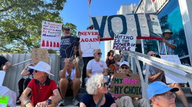 Abortion-rights activist hold signs as the sit on the stairs of the Pinellas County Judicial building in St. Petersburg. 