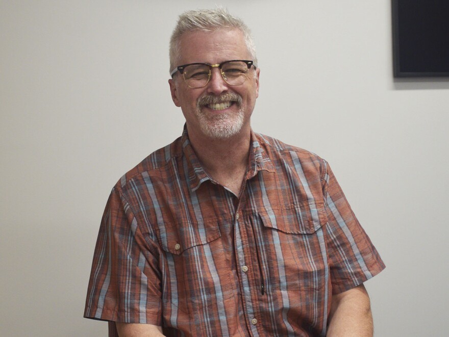 A man smiles at the camera following a radio interview. 