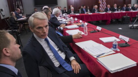 Sen. Rob Portman, R-Ohio, a member of the tax-writing Senate Finance Committee, confers with an aide as tax bill conferees gather to work on the sweeping GOP plan, on Capitol Hill in Washington, Wednesday, Dec. 13, 2017. (J. Scott Applewhite/AP)
