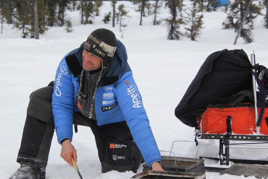 Thomas Waerner heating water in his stove in the Cripple checkpoint on Thursday, March 12, 2020. Cripple is about 425 miles into the 1,000-mile Iditarod Trail Sled Dog Race.