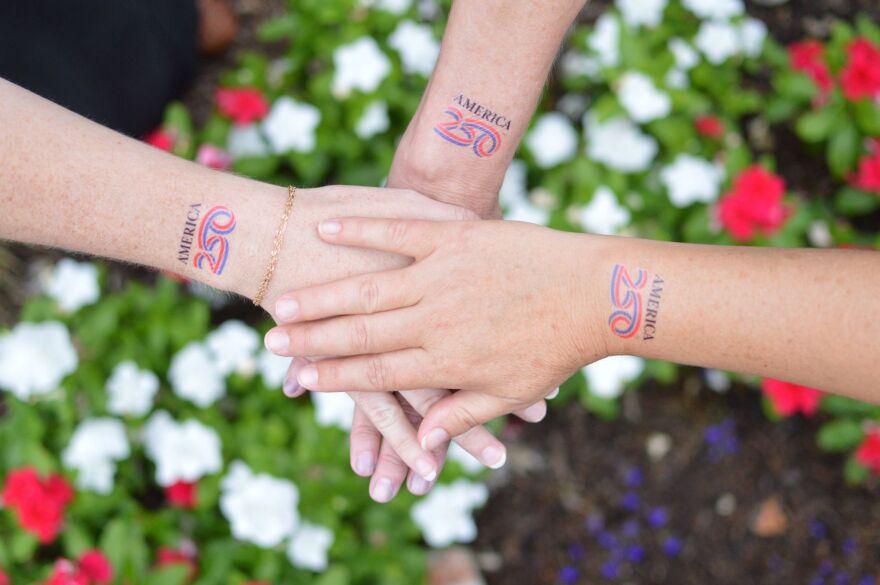 Hands marked with America 250 temporary tattoos represent community and service as Missouri celebrated America’s 250th birthday. Photo courtesy of ServMO.