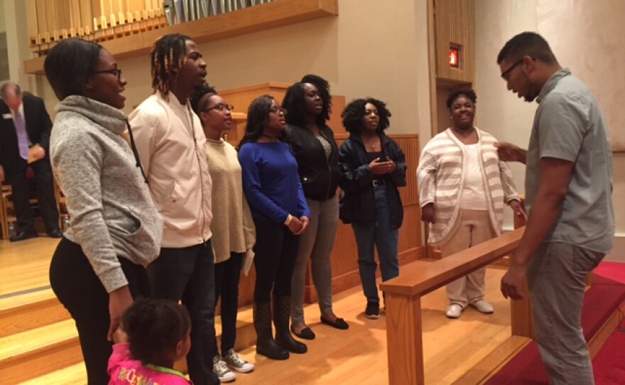 Seven choir members and director in a church
